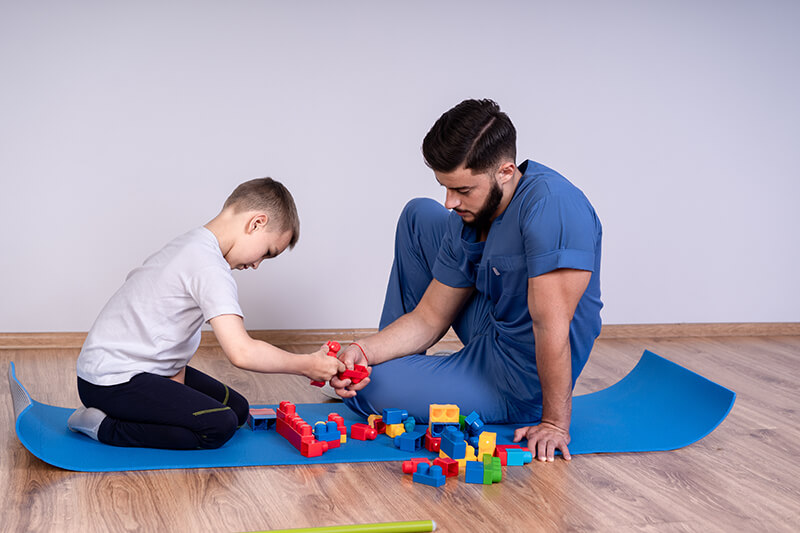 boy and therapist with blocks